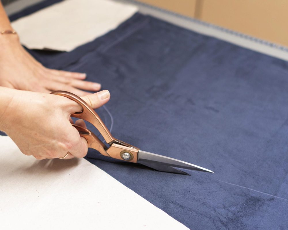 hands-cutting-material-with-scissors-close-up
